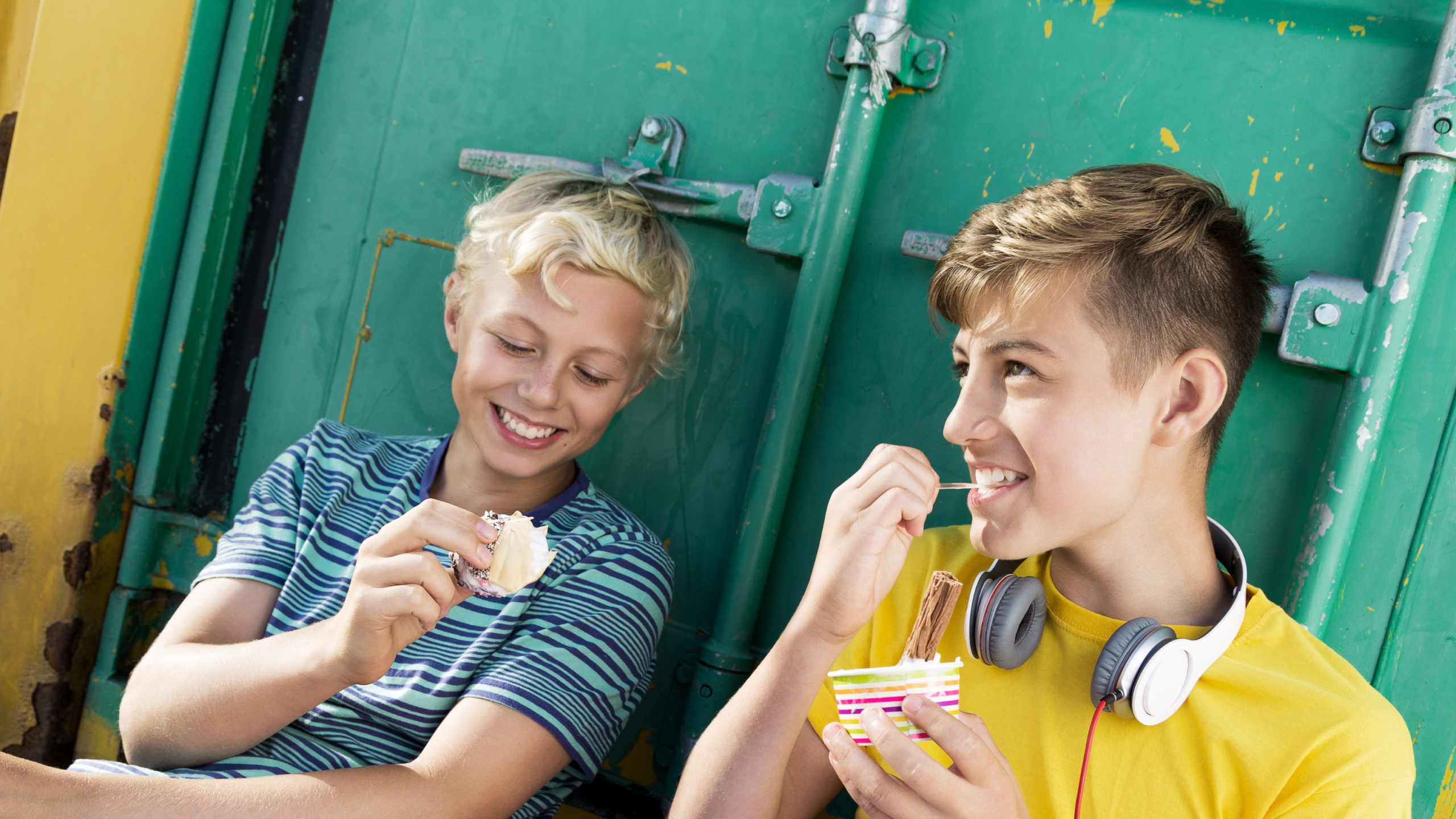 zwei Jugendliche lachen und essen Eis